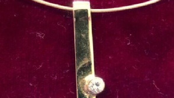 A rectangular gold pendant with a diamond inlaid.