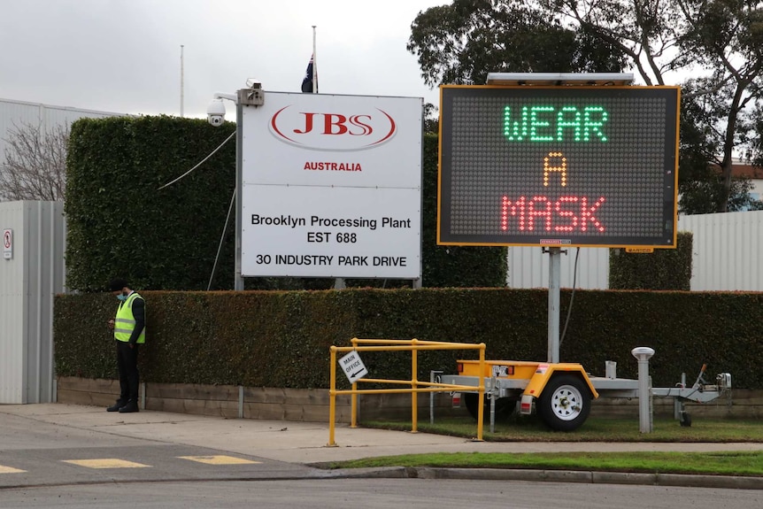 An electric sign saying 'wear a mask' outside a JBS abattoir.