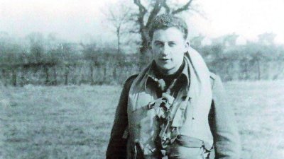 A young man wearing an old fashioned flying suit