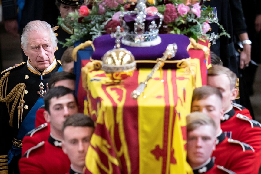 King Charles looks at coffin 