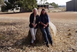 Leslee Holmes and Dahlia Richardson sitting on hay bale at the Badgingarra research station