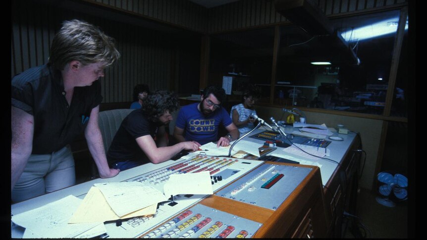 A group of staff look over the panels in the studios at Ripponlea.