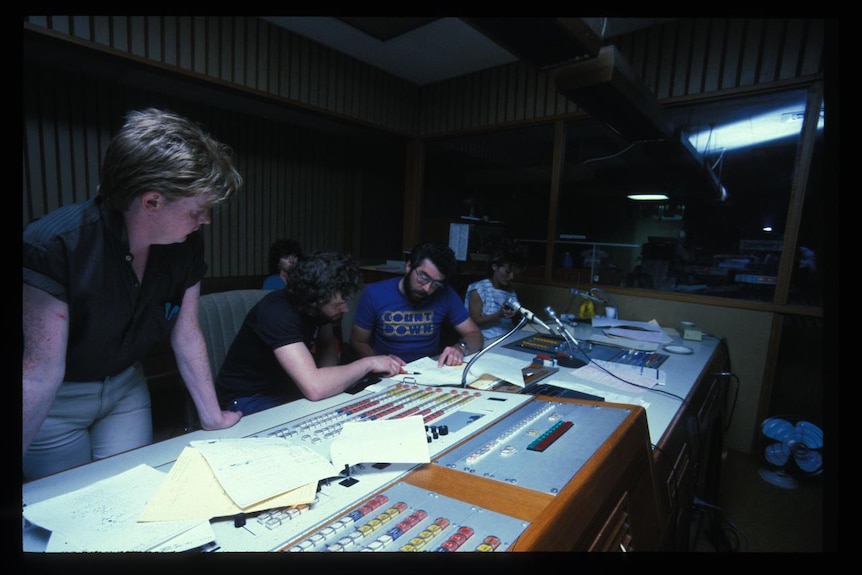 A group of staff look over the panels in the studios at Ripponlea.