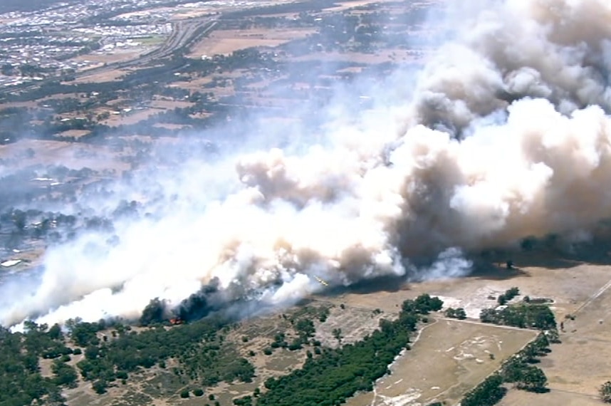 An aerial shot of a bushfire showing a big cloud of white smoke.