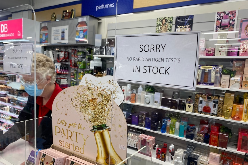 A paper sign at the counter of a pharmacy advising customers there are no rapid antigen tests left in stock.