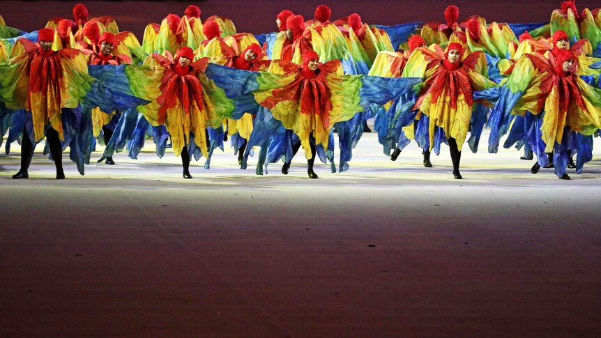 Dancers dressed as multi-coloured macaws perform during the closing ceremony.