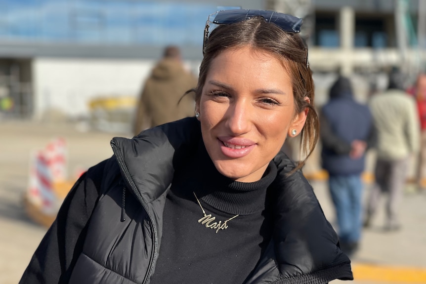 A dark-haired woman poses for a photo at Belgrade airport