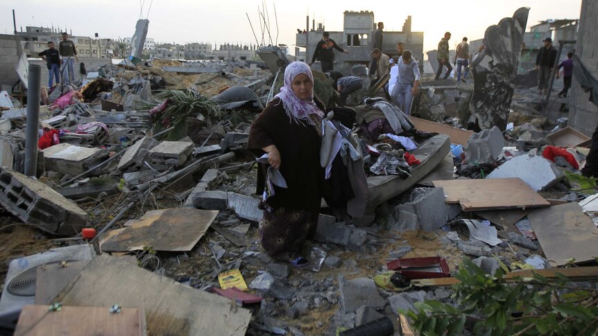 Palestinians gather their belongings in the aftermath of an Israeli air strike in Rafah, November 16, 2012.