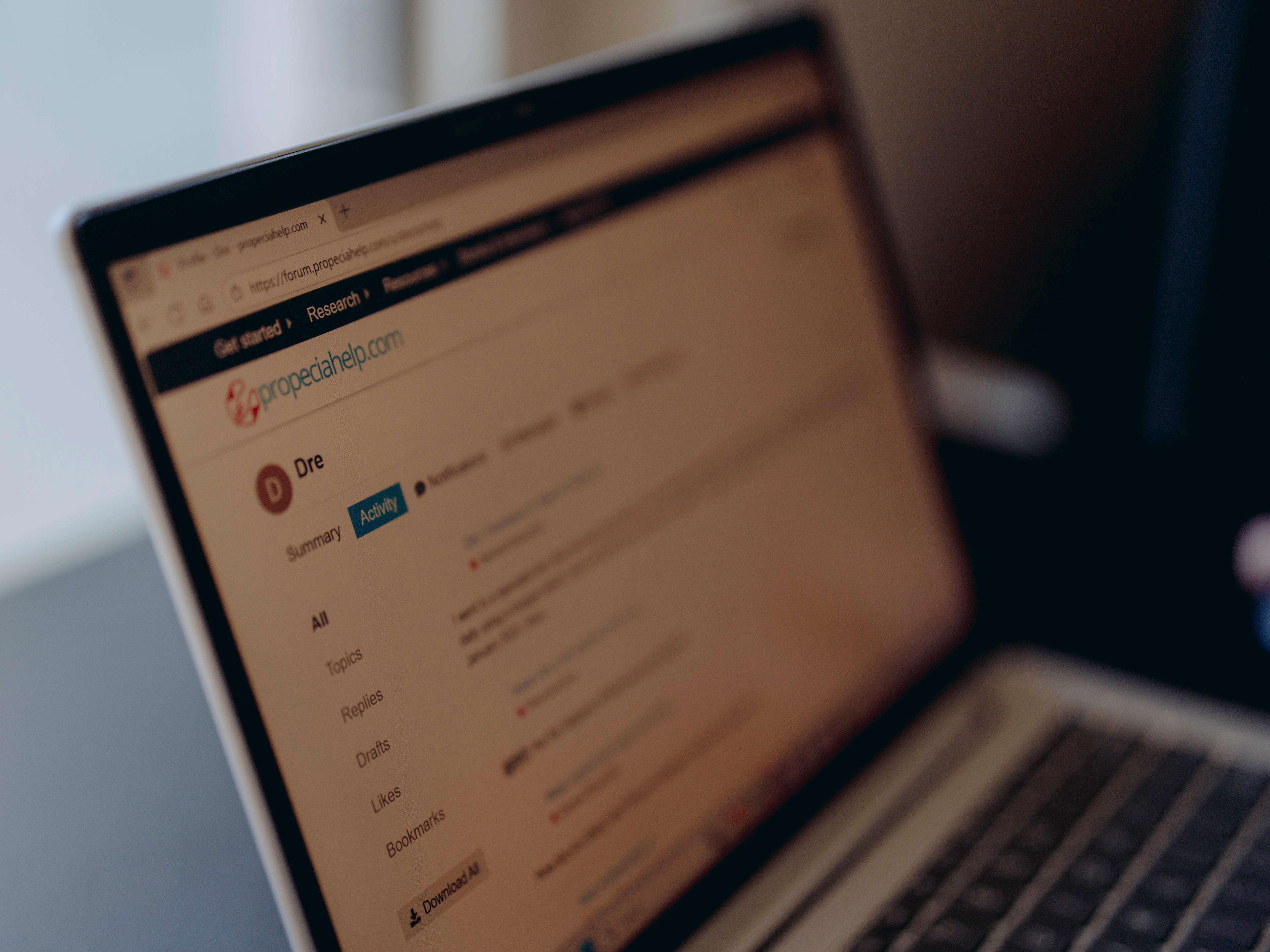 An open laptop shows an online forum. 