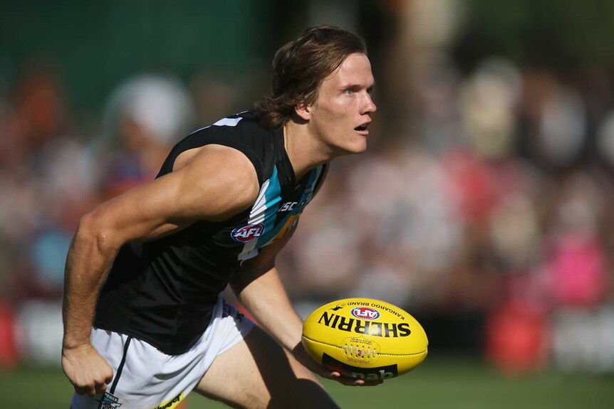 Port Adelaide's Jared Polec handballs in a preseason game against the Crows.