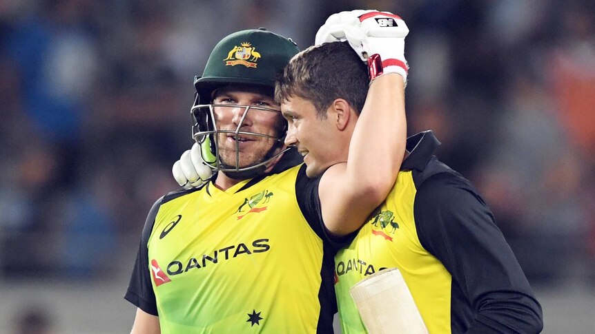 Alex Carey and Aaron Finch hug after Australia beats New Zealand.