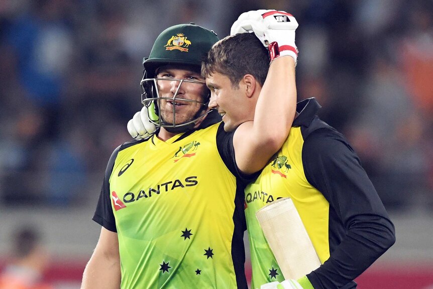 Alex Carey and Aaron Finch hug after Australia beats New Zealand.