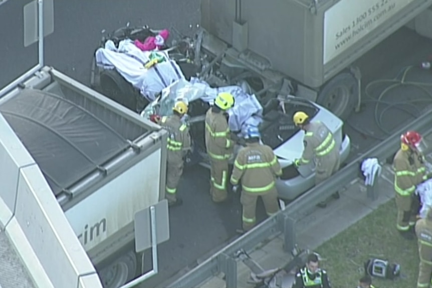 Emergency services personnel surround a car accident scene.