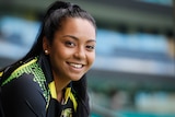 Alana King leans on the back of a chair in the stands of the SCG as she smiles at the camera
