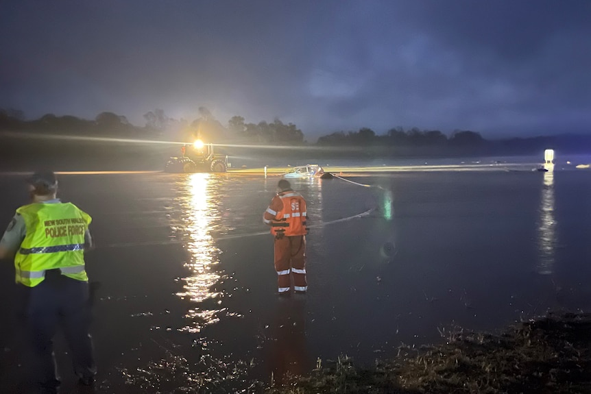 A car in floodwater at night.