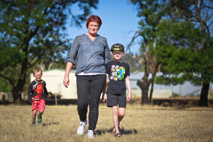 Leonie and her young sons go for a walk in a rural setting.