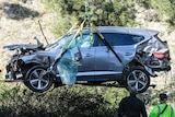 Tiger Woods's Chrysler Genesis SUV is craned up in the air after his crash in Los Angeles.