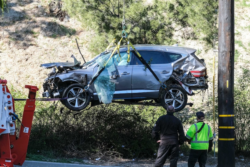 Tiger Woods's Chrysler Genesis SUV is craned up in the air after his crash in Los Angeles.