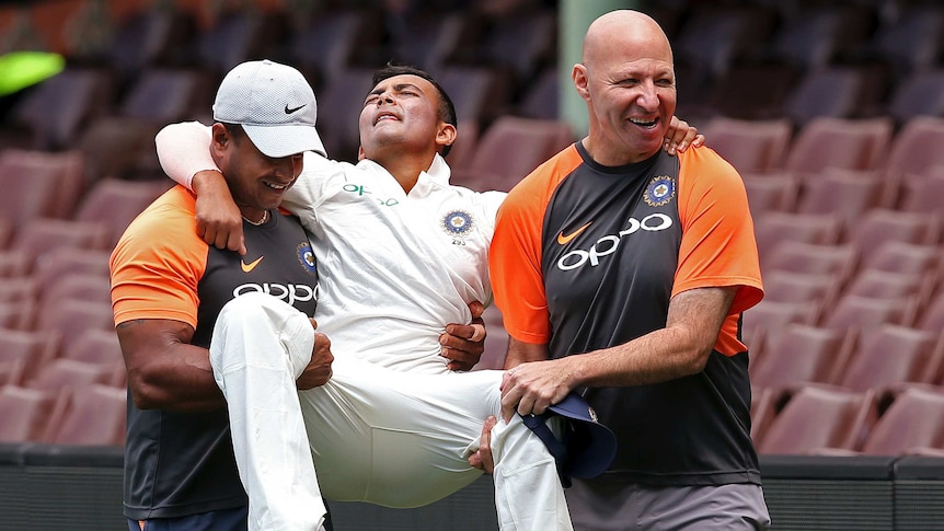 India's Prithvi Shaw (C) is carried off after rolling his ankle at the SCG on November 30, 2018.
