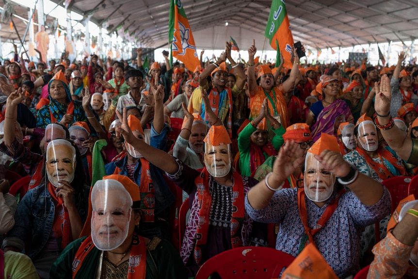 Bharatiya Janata Party (BJP) supporters wear masks of Indian Prime Minister Narendra Modi during an election rally.
