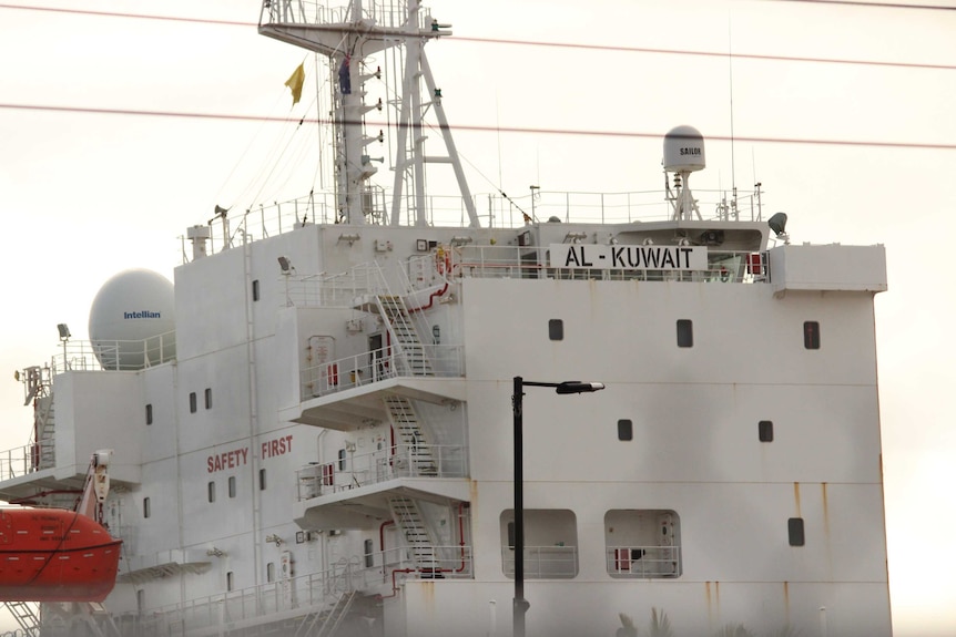 The live export ship Al Kuwait docked in Fremantle in the daytime with port cranes behind it.