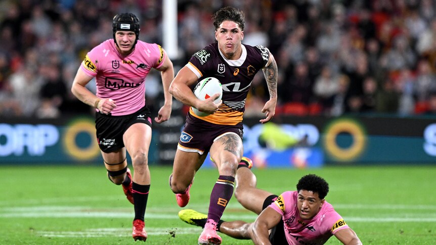 Brisbane Broncos' Reece Walsh runs away from Penrith Panthers defenders during an NRL game.