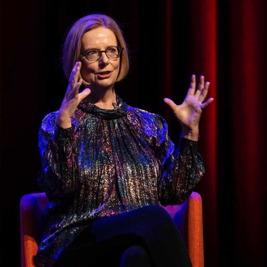 Former Australian prime minister Julia Gillard makes a hand gesture on on stage at Hobart's Theatre Royal
