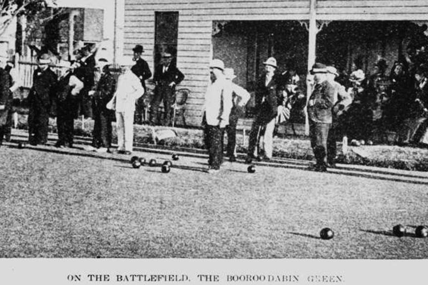 Black and white photo of men playing bowls.