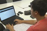 An engineering student works on his laptop