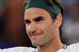 Roger Federer holds his hands up