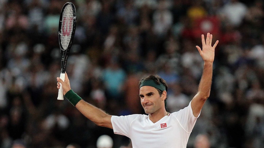 Roger Federer holds his hands up