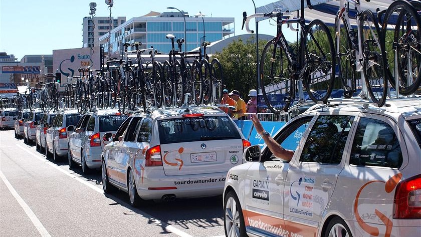 Support vehicles wait to follow the riders out before the start of the Tour Down Under Classic.