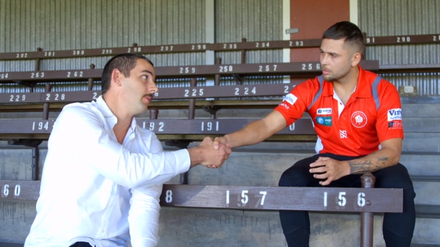 Adelaide Crows player Taylor Walker shakes hands with North Adelaide's Robbie Young.