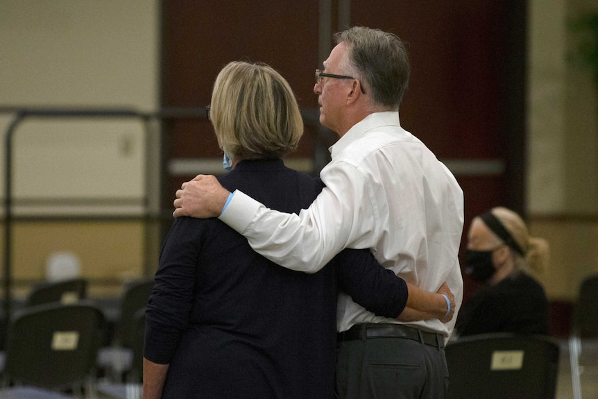 Bob and Gay Hardwick standing in a court room with their arms around each other