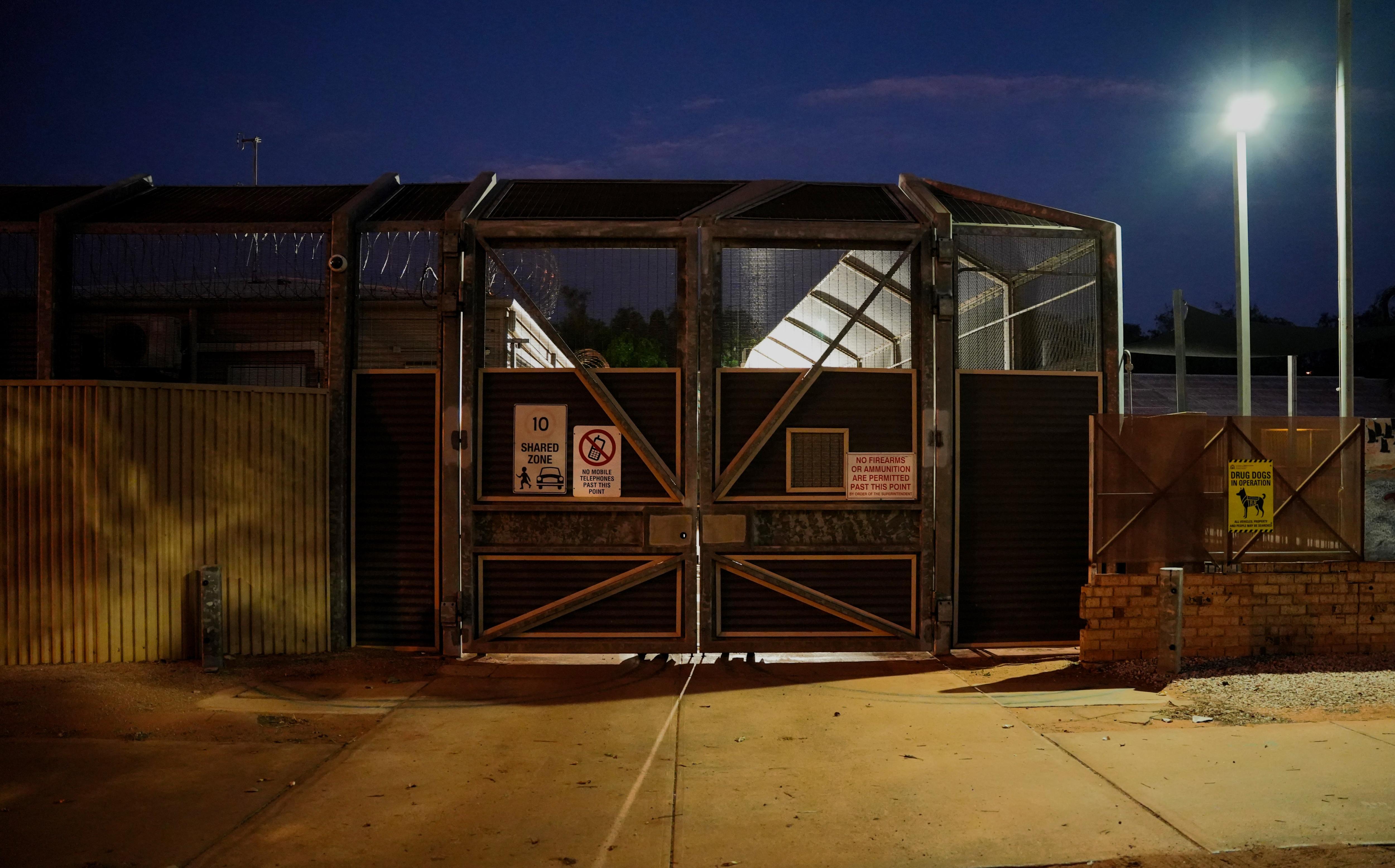 Um prédio com portões de segurança à noite. 