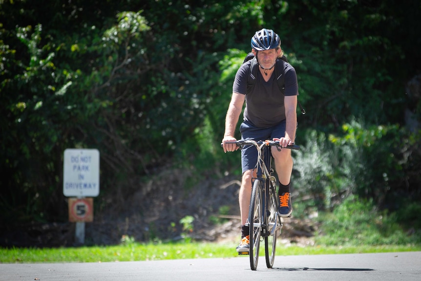 A middle-aged man riding a bicycle 