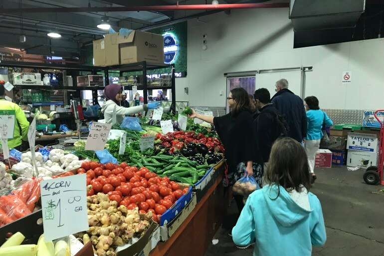 Woman purchases fruit from produce market.