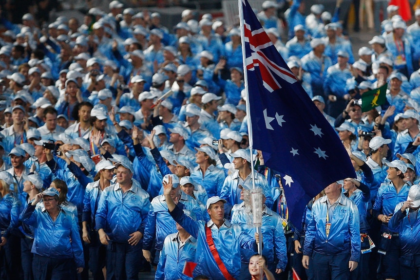 James Tomkins carrying an Australian flag and leading the athletes out at the opening ceremony in 2008