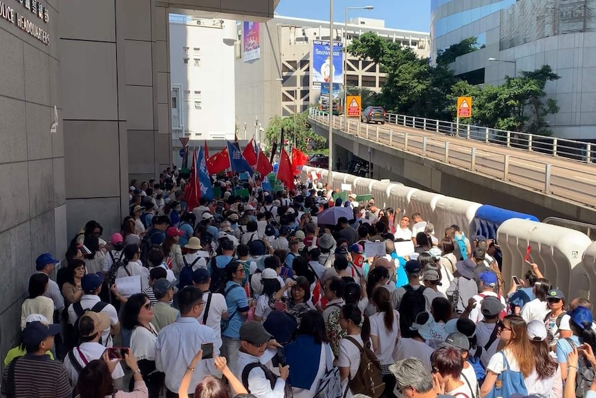You look down at a crowd of hundreds as they are wedged between barricades and the walls of the Hong Kong police headquarters.
