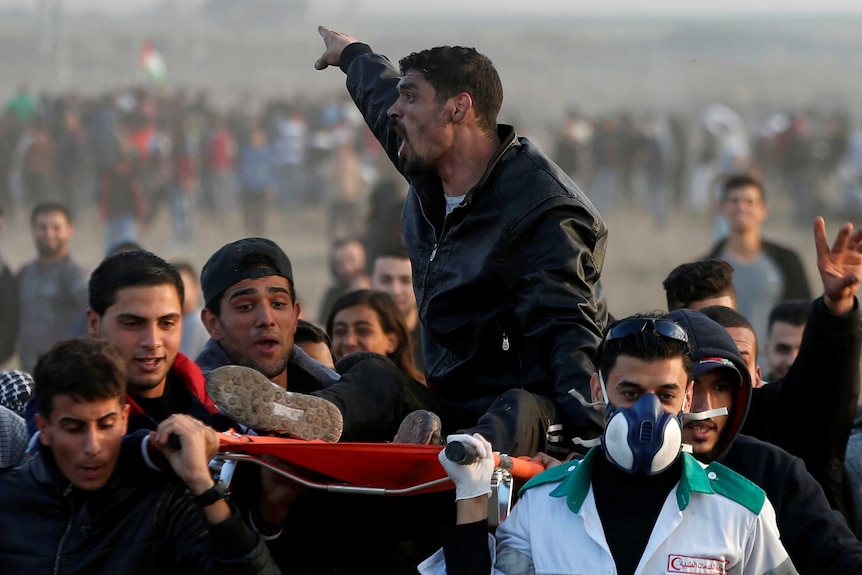 A wounded Palestinian shouts as he is evacuated during clashes with Israeli troops.