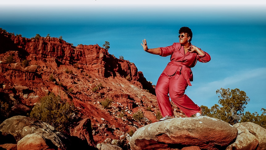 Brittany Howard dancing atop a rock in the desert