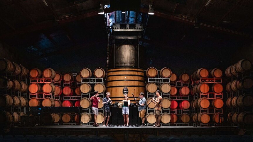 Four musicians perform in the barrel room of a winery