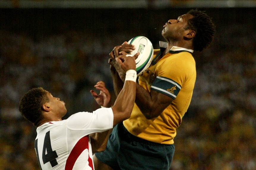 Lote Tuquiri jumps over Jason Robinson and catches a rugby ball