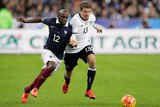 Thomas Mueller of Germany (R) is challenged by France's Lassana Diarra (L) at Stade de France.
