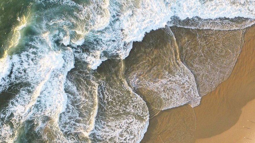 Looking down on waves breaking on beach