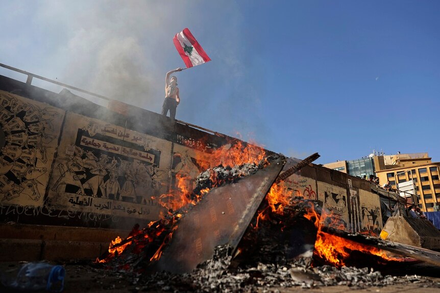 A protester waves a Lebanese flag on a road leading to the parliament building in Beirut.