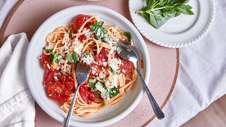 A bowl of linguini with slow roasted tomato sauce topped with basil and parmesan cheese, for a weeknight or special dinner.