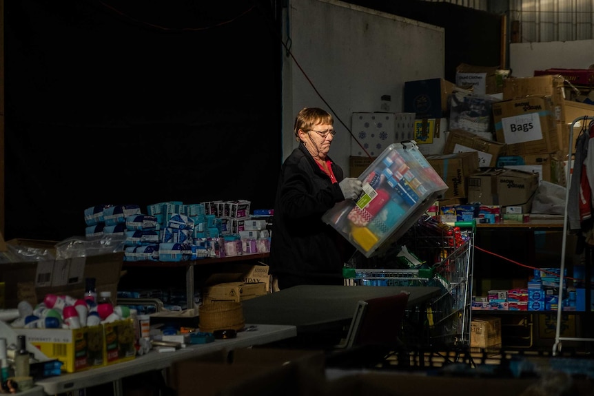 Volunteer carries a box  in the Cobargo bushfire relief centre