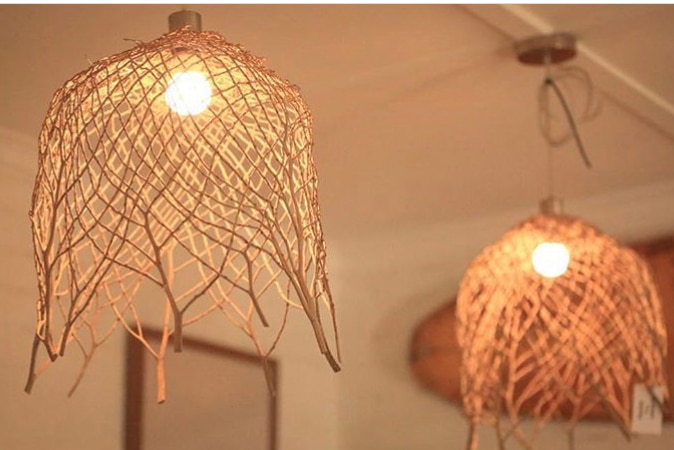 Two light shades made of woven materials sit over lights that hang from the ceiling.