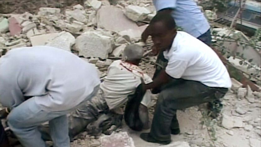 An injured person is pulled from a structure that collapsed after an earthquake in Port-au-Prince